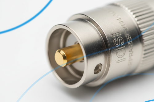 Macro of BNC connector with light catching gold plating on clean white background with blue accent